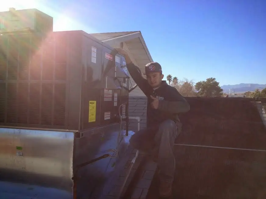 HVAC technician performing Boiler Repair on a rooftop unit in Norwalk